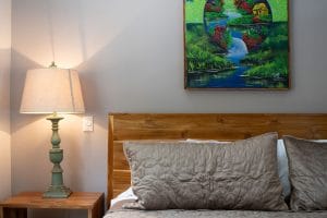Bedroom of Casa Fenix in Playa Potrero, Guanacaste. Lush pillows and nightlamp on a table.