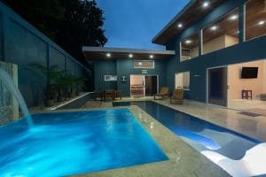 Casa Carlayna poolside view with both pool and jacuzzi surrounded by pool chairs.